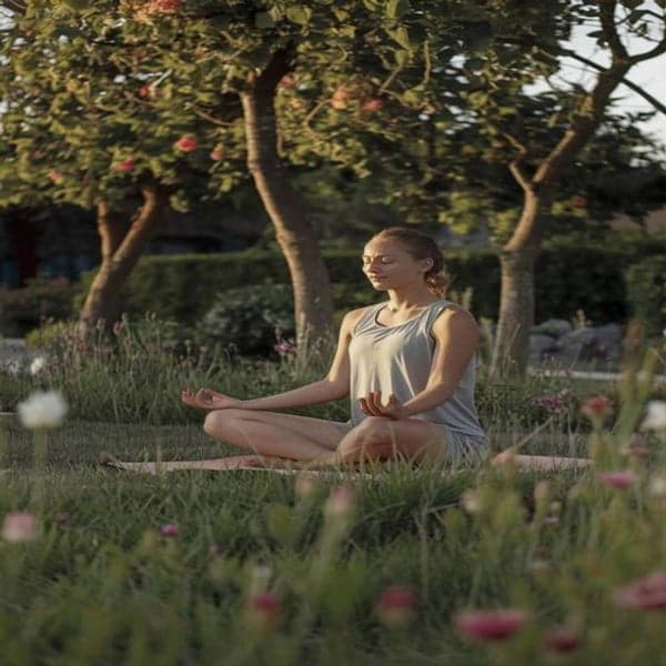 A woman meditating in a garden